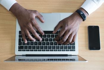man's hands typing on laptop keyboard